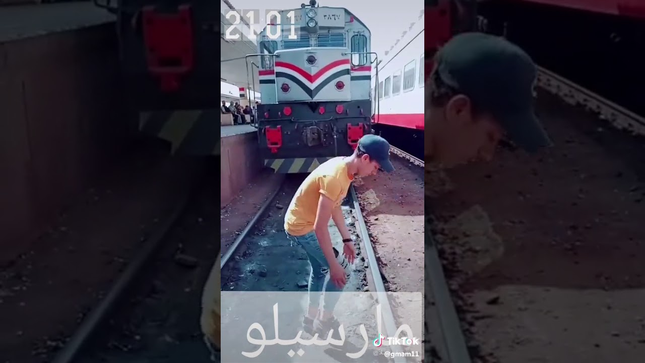مفاجئة شاب مصري يقف في محطة القطار السريع يقف على السكة الحديدية وأمامه قطار يطلع