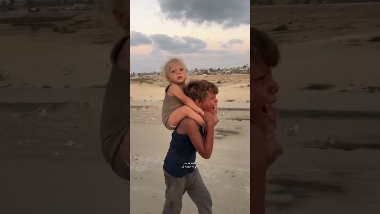طفل فلسطيني يحمل شقيقته في غزة 🇵🇸