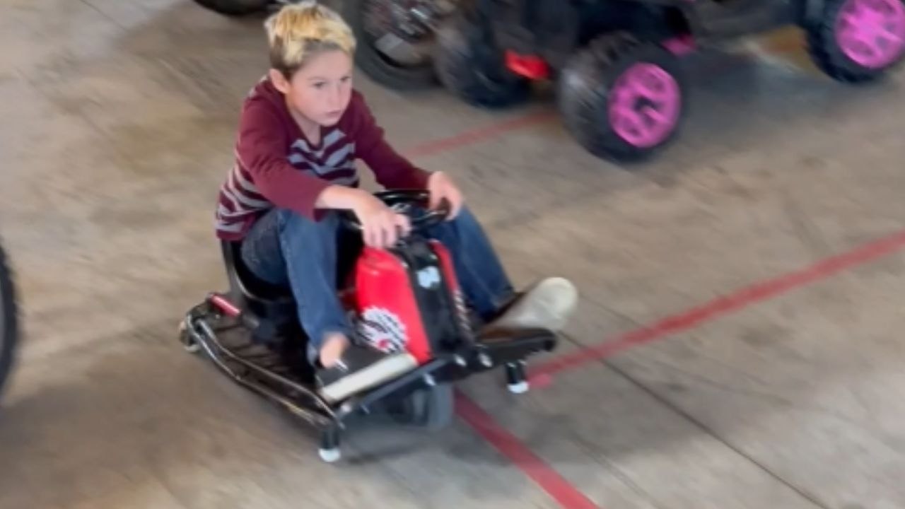 Boy does a fun front wheel balancing trick with a crazy cart