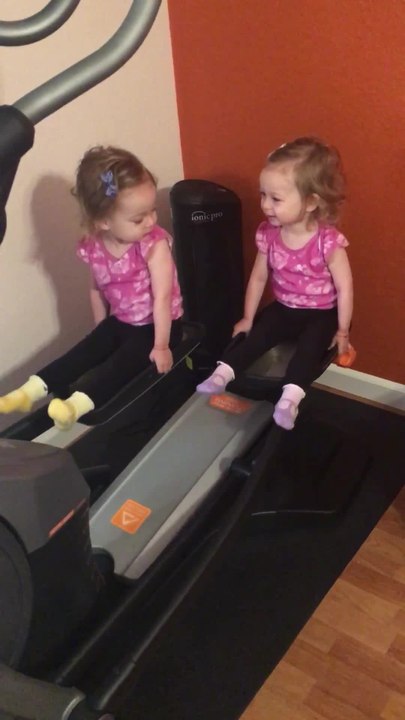 Twin girls take over elliptical machine