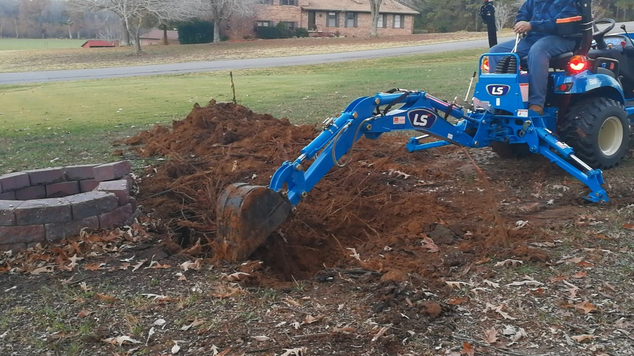 LS MT125 Subcompact Tractor digging stump