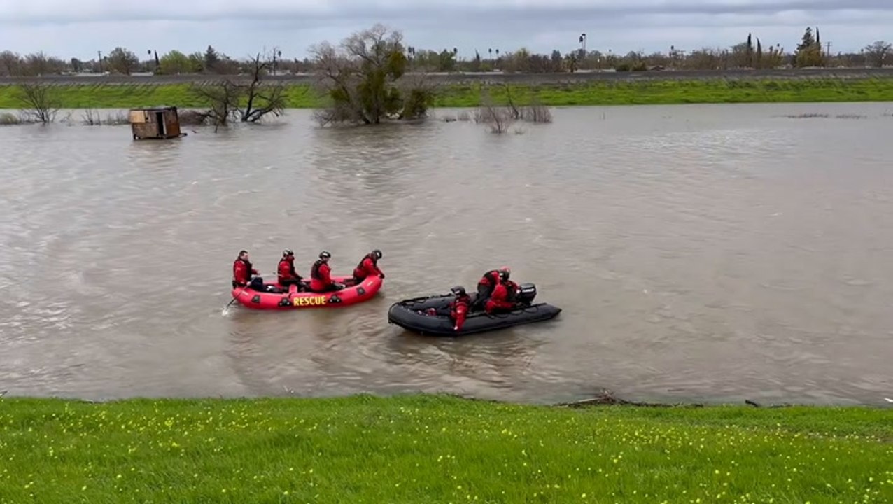 Two people and dog rescued from makeshift shelter surrounded by floodwater