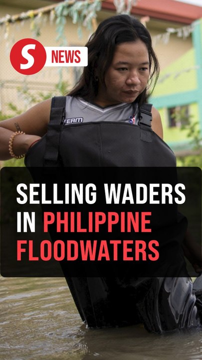 Selling waders in waist-high Philippine floodwaters