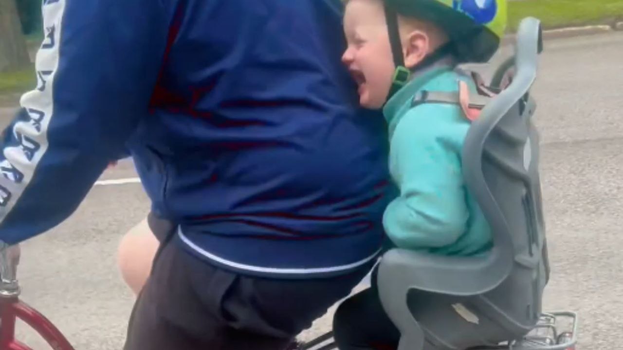 Child's laughter fills the air while riding through bumpy path on bike with her dad